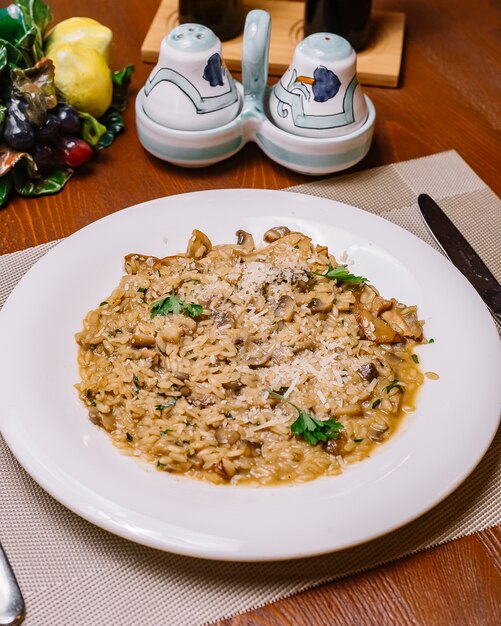 Risotto bord met champignons gegarneerd met geraspte parmezaan en peterselie