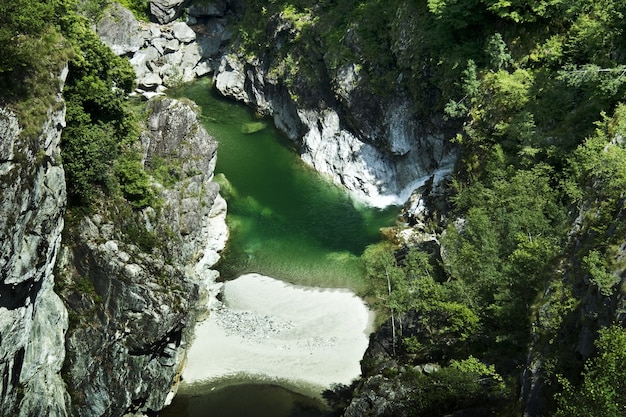 Gratis foto rivier omgeven door grote bergen onder het zonlicht