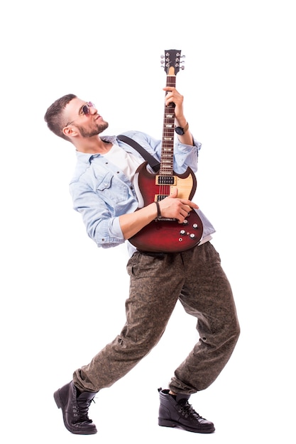 Rock star man met een gitaar geïsoleerd over witte muur