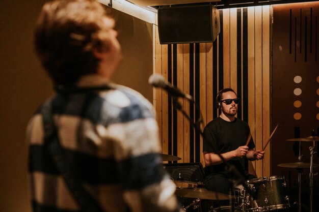 Rockbanddrummer die herhaling uitvoert in opnamestudio