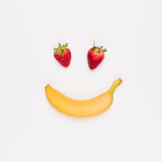 Rode aardbeien en gele bananen op witte achtergrond