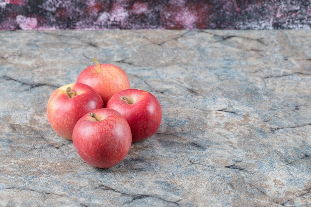 Rode appels geïsoleerd op betonnen marmeren achtergrond.