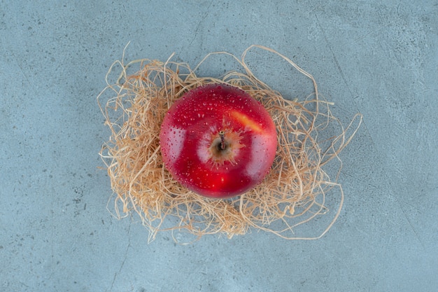 Rode appels op droog stro, op de marmeren achtergrond. Hoge kwaliteit foto