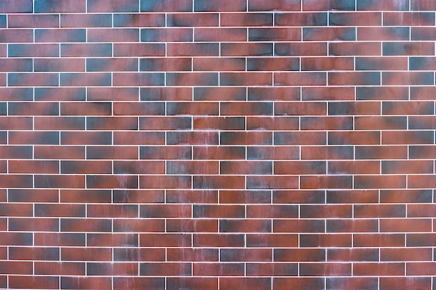 Rode bakstenen muur. Textuur van donkerbruine en rode baksteen met witte vulling