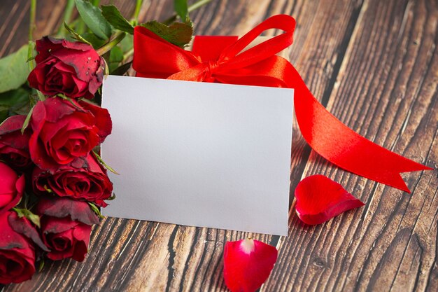 Rode bloemen van roos en omhullen op donkere houten achtergrond