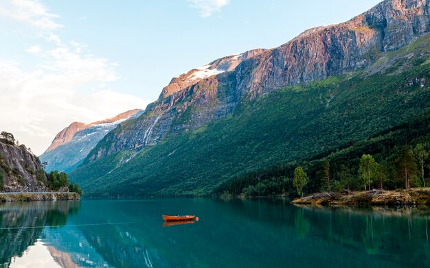 Rode boot afgemeerd aan het idyllische meer in de buurt van de rocky mountains