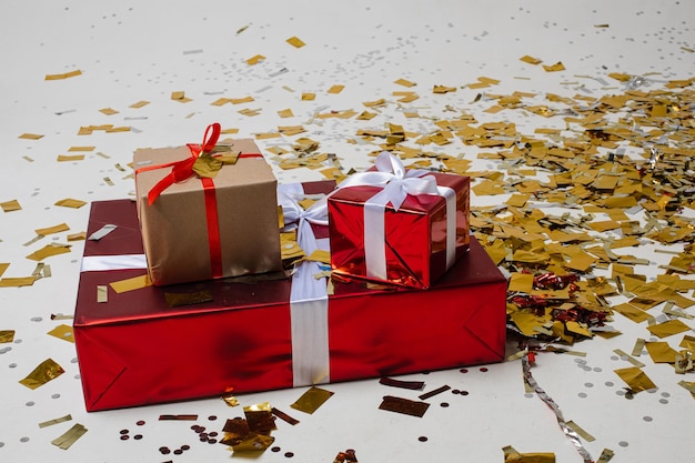 Rode en bruine dozen met cadeautjes in een mooie verpakking met heel veel gouden confetti eromheen