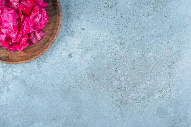 Rode gefermenteerde zuurkool op een houten plaat op het blauwe oppervlak