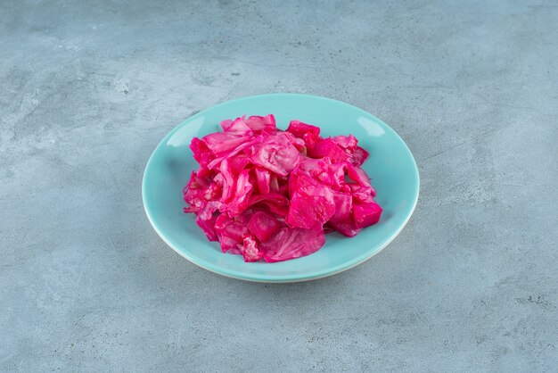 Rode gefermenteerde zuurkool op plaat op het blauwe oppervlak