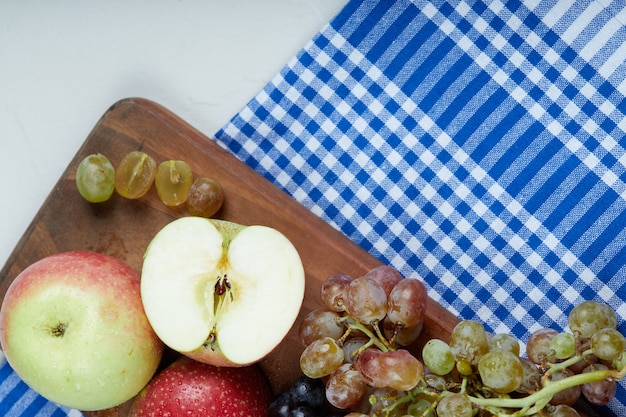 Rode groene appels en druiventrossen op een houten bord.