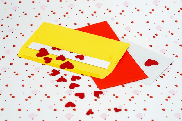 Rode kleine harten die uit de envelop komen op de achtergrond van de valentijnsdag met kopieerruimte, liefdesbriefconcept, close-up