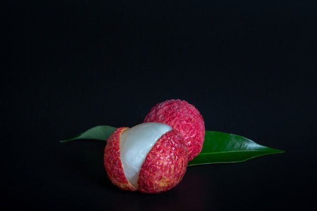 Rode litchifruit die in een mand wordt geplaatst.