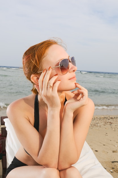 Gratis foto rode meid op het strand