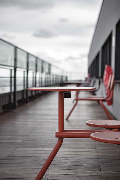 Rode metaaltafel en stoelen op houten dek