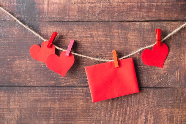 Rode papierharten en envelop met spelden die op draad hitching