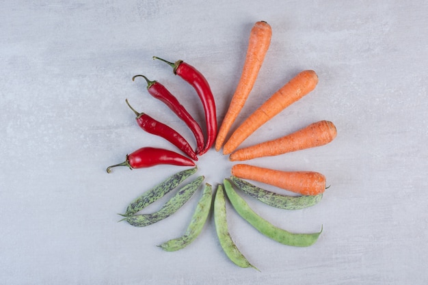 Rode paprika's, groene bonen en wortelen op stenen achtergrond. Hoge kwaliteit foto