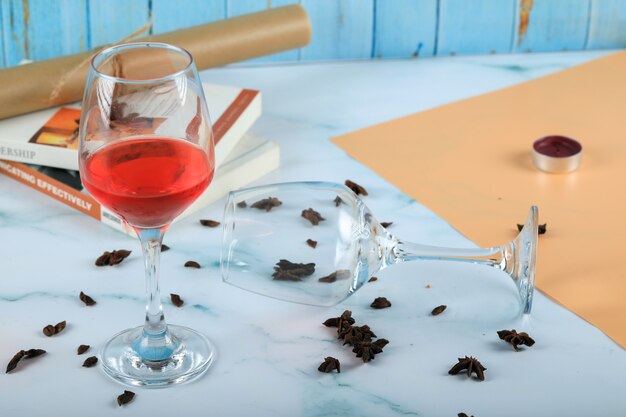 Rode roos in een glas en een leeg wijnglas op het karton