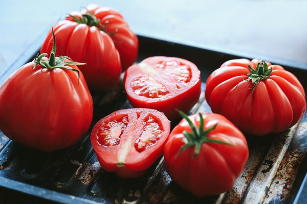 Rode tomaten die op de zwarte pan grillen