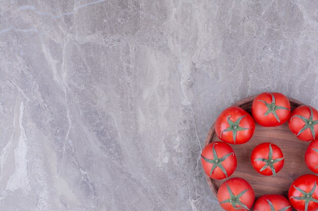 Rode tomaten geïsoleerd in een houten schotel.