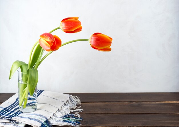 Rode tulpen in glazen vaas op tafel