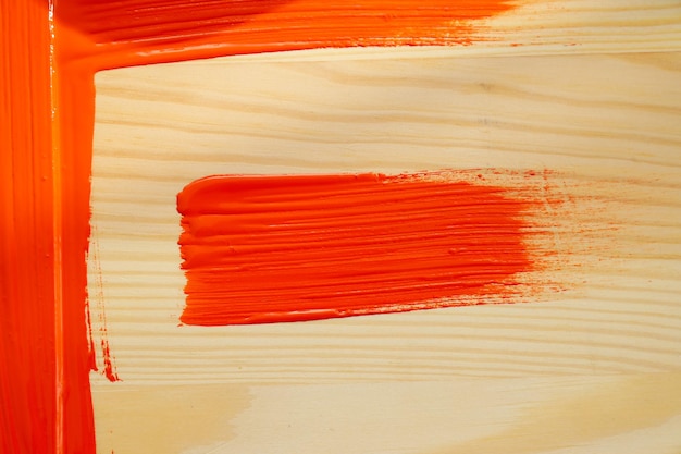 Gratis foto rode verfvlek op houten achtergrond close-up