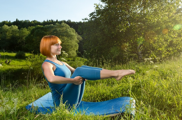 Rode vrouw oefenen fitness yoga buitenshuis