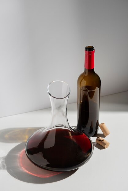 Gratis foto rode wijn karaf en fles arrangement hoge hoek
