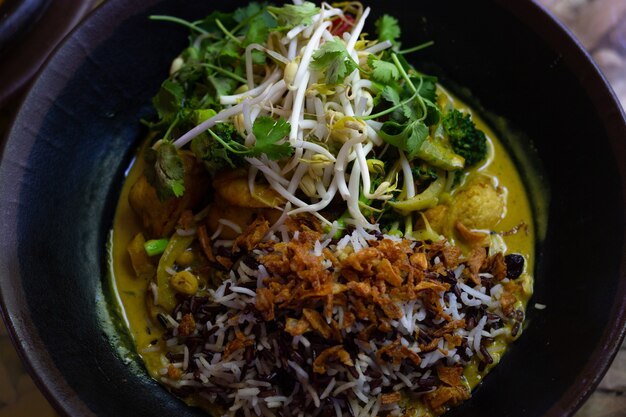 Roerbak gele curryplaat met kipgarnalen en sojascheuten traditioneel thais eten