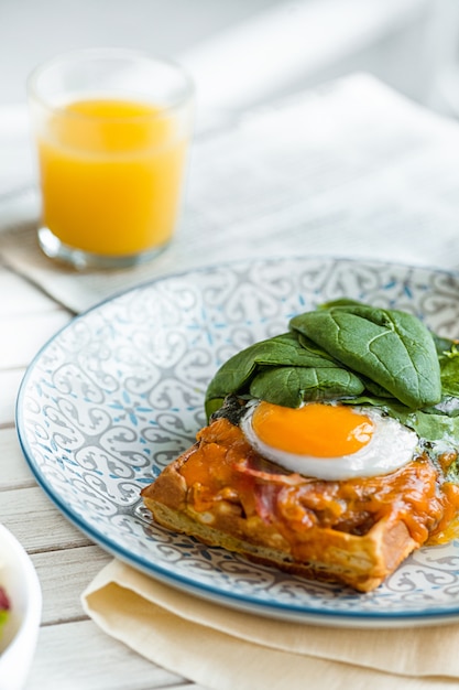 Roerei op vlees met gebakken aardappelen en toast op plaat op houten tafel