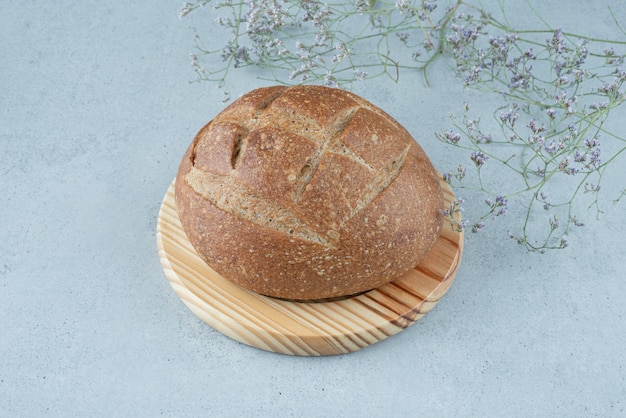 Roggebroodje op een houten bord met plant