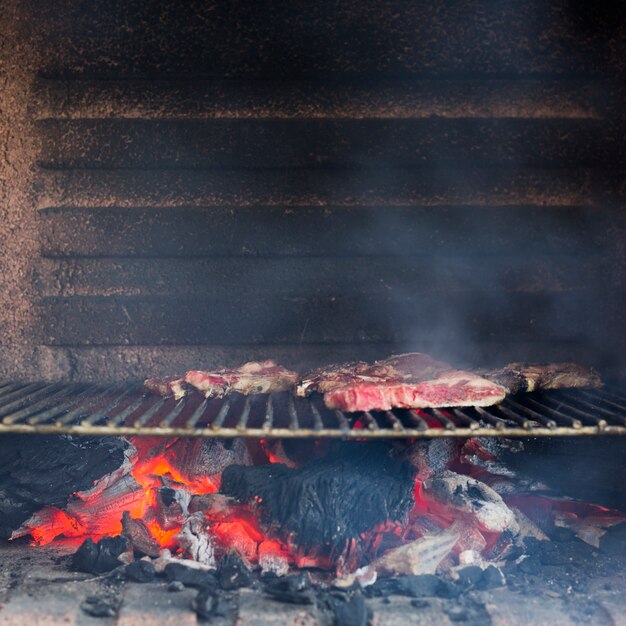 Rokerig geroosterd vlees op gebakken metaalplaat in de barbecue