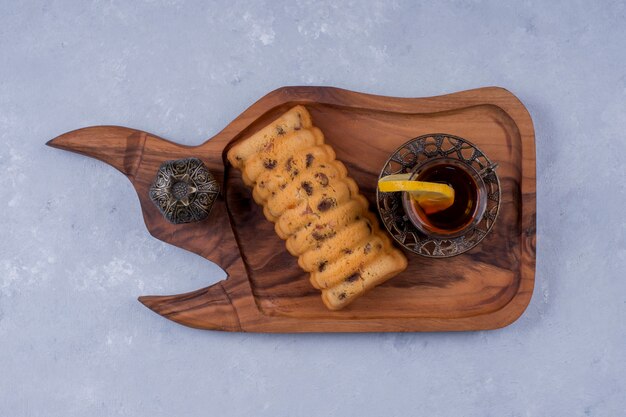 Rollcake geserveerd met earl grey thee in een houten schotel, bovenaanzicht