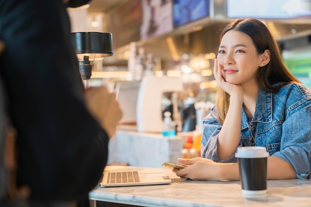 Romantisch aantrekkelijk mooi aziatisch stel vrouw blij om zijn vriendje te ontmoeten die in café coffeeshop komt love dating food lifestyle concept