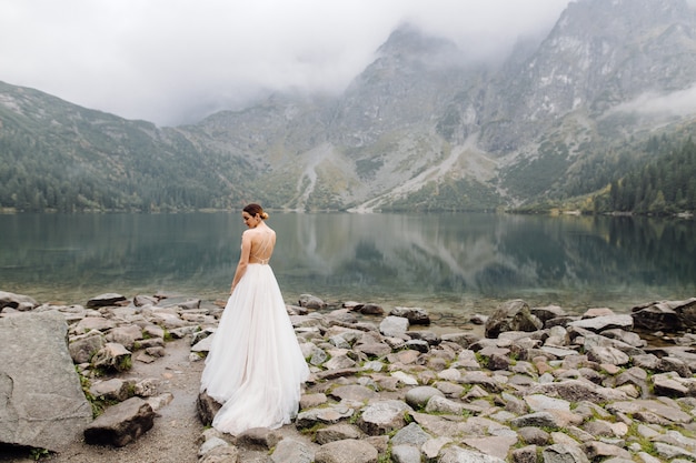 Gratis foto romantisch huwelijkspaar in liefde status van het sea eye-meer in polen. tatra-gebergte.