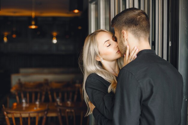 Gratis foto romantisch jong koppel knuffelen bij café raam