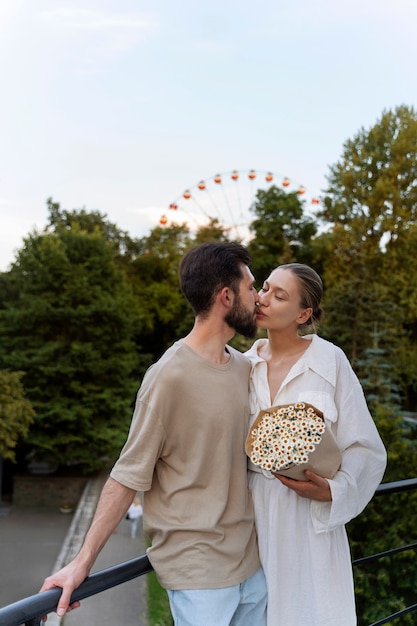 Gratis foto romantisch koppel samen op pad bij het reuzenrad in het park