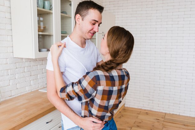 Romantisch paar dat in keuken omhelst