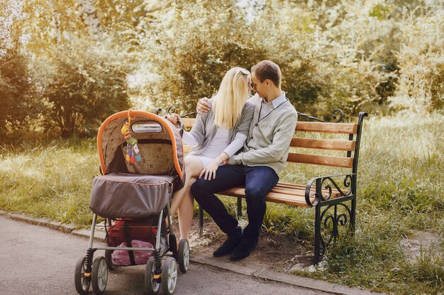 Romantisch paar met kinderwagen op een bankje in het park