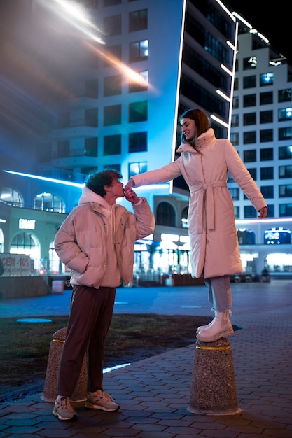 Gratis foto romantisch paar 's nachts genietend van het stadsleven