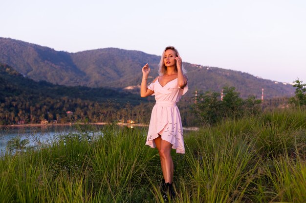 Romantisch portret van jonge Kaukasische vrouw in zomerjurk genieten van ontspannen in het park op de berg met prachtig uitzicht op de tropische zee.Vrouw op vakantie reizen rond Thailand Gelukkige vrouw bij zonsondergang