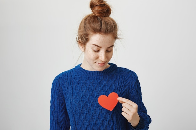 Gratis foto romantisch schattig roodharig meisje met hart teken