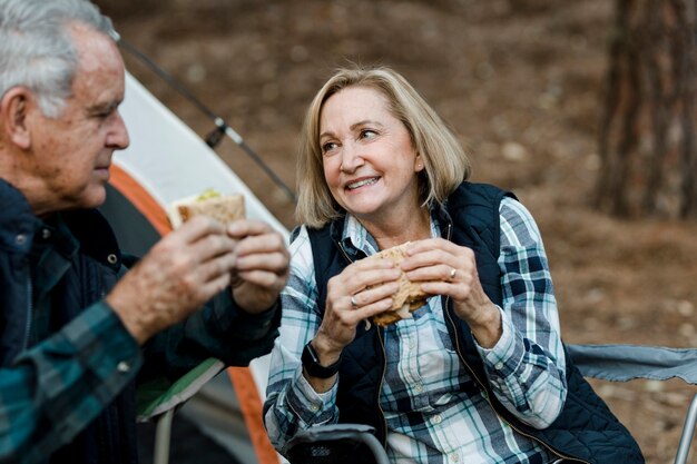 Romantisch senior koppel aan het picknicken bij de camping