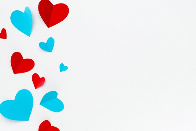 Romantische compositie gemaakt met rode harten op witte achtergrond met copyspace voor tekst
