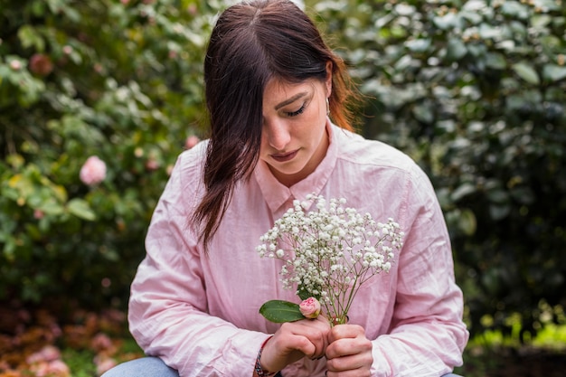 Gratis foto romantische vrouw met hoop van bloemen in park