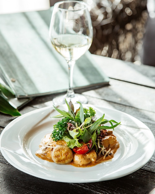 Romige champignonschotel gegarneerd met groene salade met tomaat