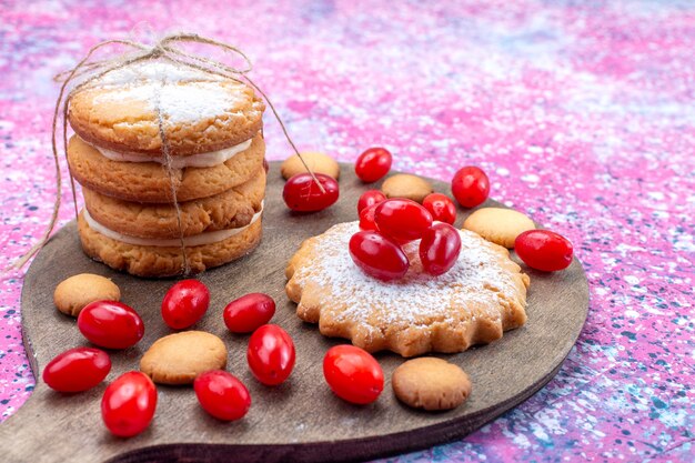 romige sandwichkoekjes met rode kornoeljes op heldere, koekjescake koekje zoetzure fruitbes