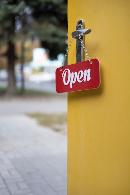 Rood open bord dat aan de deurknop hangt