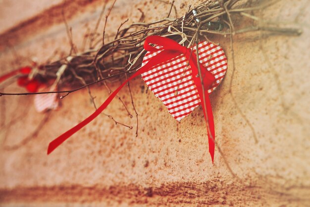 Rood ornament in de vorm van een hart dat op een tak hangt
