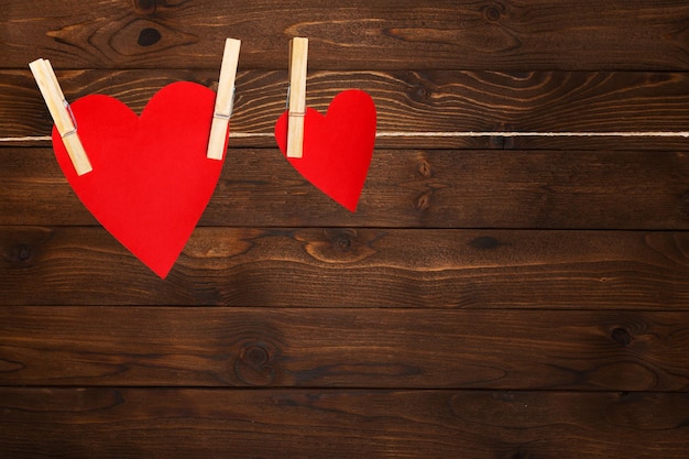 Rood papieren hart Valentines hangend aan het touw aan de wasknijper