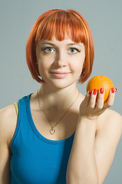 Roodharig meisje met sinaasappel